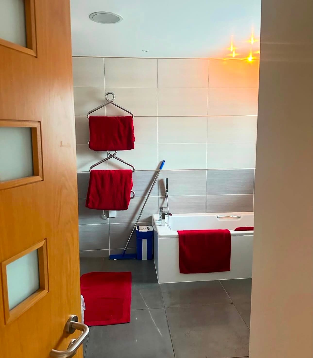 a tiled bathroom with fresh towels folded on the rail