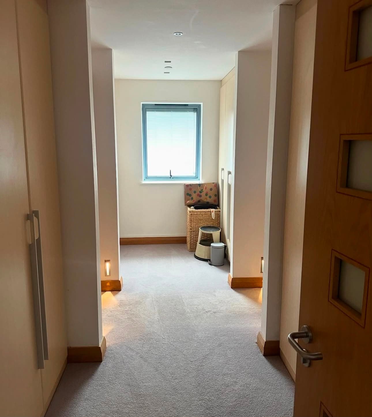 a carpeted landing, vacuumed, looking through to a bedroom